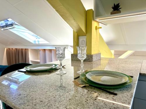 - une table avec deux assiettes et des verres dans l'établissement Joli studio, idéalement situé, très proche Gare, à Nice