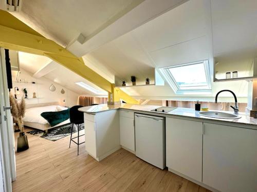 - une cuisine avec évier et un lit dans une chambre dans l'établissement Joli studio, idéalement situé, très proche Gare, à Nice