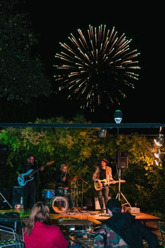 a band playing on a stage with fireworks in the background at Hotel Limone in Limone sul Garda