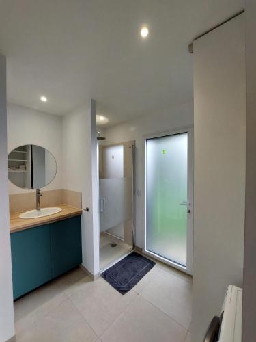 une salle de bain avec un lavabo et un miroir dans l'établissement Studio confort proche de la mer sur la côte d'Emeraude - Le Minihic sur Rance, à Le Minihic-sur-Rance