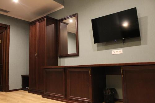 a living room with a flat screen tv on the wall at Green Duck Hotel in Kharkiv