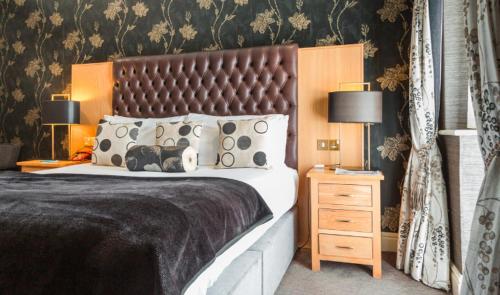 a bedroom with a large bed and two lamps at Thornton Hall Hotel & Spa in Heswall