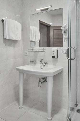 a white bathroom with a sink and a mirror at Optima Collection Gallery Poltava in Poltava
