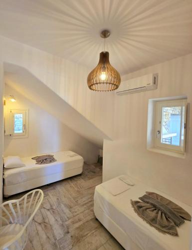 a room with two beds and a chandelier at Paros Afrodite Luxury Villas in Aliki