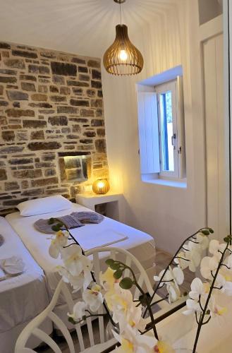 a bedroom with two beds and a table and a window at Paros Afrodite Luxury Villas in Aliki