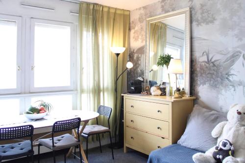 une chambre avec un lit, une table et un miroir dans l'établissement Bright studio in the heart of Paris, à Paris
