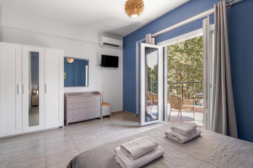 a blue bedroom with a bed and a sliding glass door at Oasis Exclusive in Parga