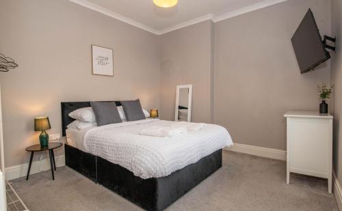 a bedroom with a bed and a flat screen tv at Number 3 Castle Cottage in Skipton