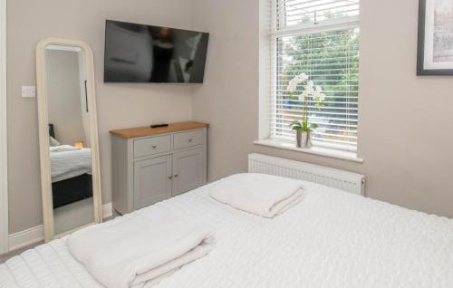 a white bedroom with a mirror and a bed at Number 3 Castle Cottage in Skipton