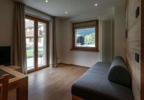 a living room with a couch and a large window at BAITA LARIX BORMIO in Bormio