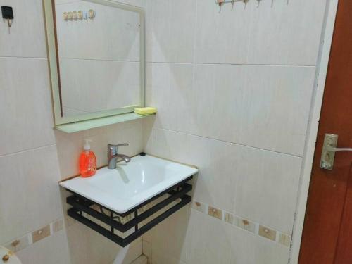une salle de bain blanche avec un lavabo et un miroir dans l'établissement AT Unicorn Homestay Sibu - Large Parking, High-Speed WiFi, Wedding House, à Sibu