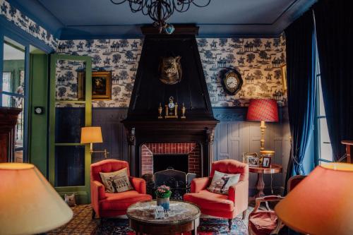 a living room with red chairs and a fireplace at Château de Picheny in Picheny