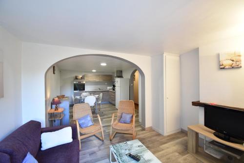un salon avec un canapé et des chaises et une cuisine dans l'établissement Aire Ona 2 - Hossegor appartement situé à proximité de la plage de la gravière, à Soorts-Hossegor