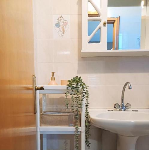 a bathroom with a sink and a mirror and a plant at Room Ntina Kastraki in Kastraki