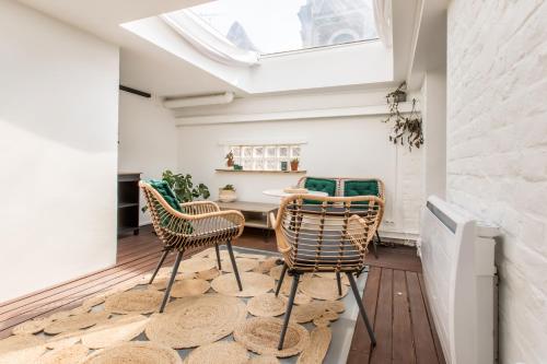 d'une salle à manger avec une table, des chaises et une lucarne. dans l'établissement Duplex d'Exception avec Patio Privé - Hyper Centre, à Lille