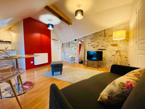 - un salon avec un canapé et un mur rouge dans l'établissement Casa Ma Maine, à Bouchemaine