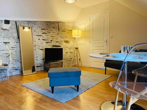 - un salon avec une table et une ottomane bleue dans l'établissement Casa Ma Maine, à Bouchemaine