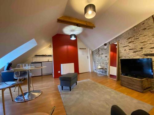 un salon avec une télévision et un mur en pierre dans l'établissement Casa Ma Maine, à Bouchemaine