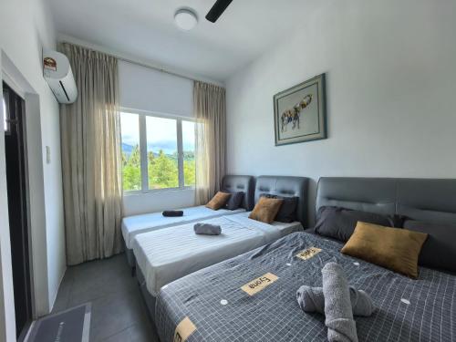 a bedroom with two beds and a window at Langkawi Simfoni Cassia Suite 04 9pax in Kuah