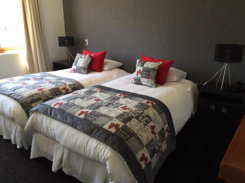 two beds in a hotel room with red pillows at Martina de Goñi in Pucón