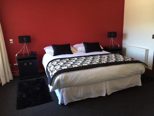 a bedroom with a large bed with red walls at Martina de Goñi in Pucón