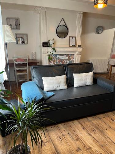 a black couch sitting in a living room at Duplex au lin in Saint-Pol-de-Léon