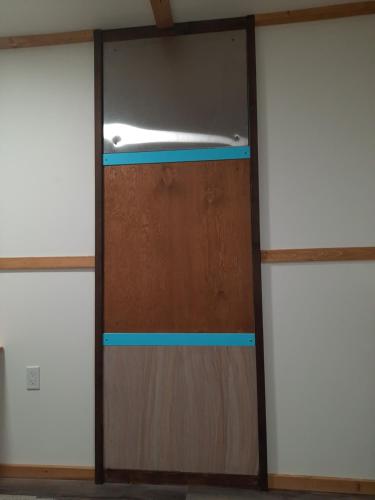 a wooden door in a room with two windows at Hampton Haven & Jacuzzi in Saskatoon
