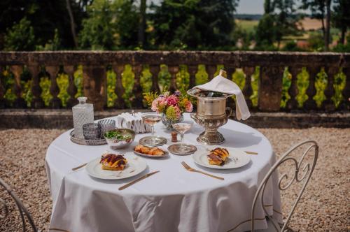 a white table with plates of food on it at Château de Picheny in Picheny
