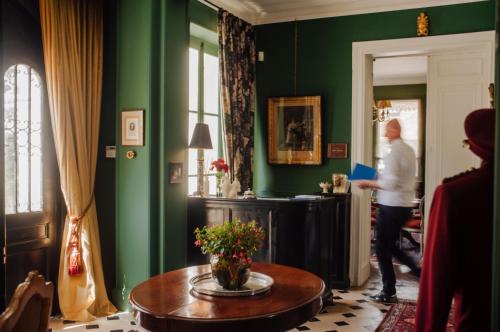 a person standing in a green room with a table at Château de Picheny in Picheny
