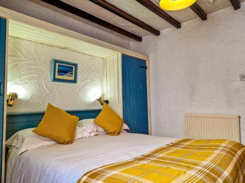 a bedroom with a bed with yellow pillows at Clyne Farm Centre in The Mumbles