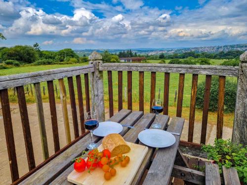 a wooden table with two glasses of wine and vegetables at Clyne Farm Centre in The Mumbles