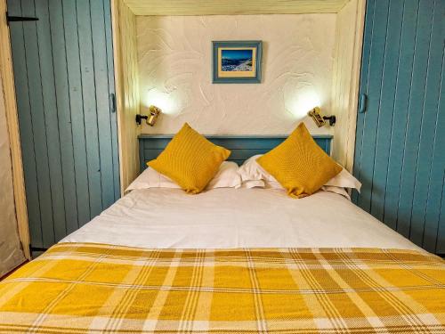 a bedroom with a bed with yellow pillows at Clyne Farm Centre in The Mumbles