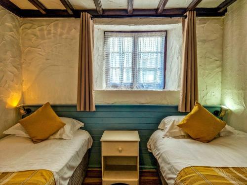 two twin beds in a room with a window at Clyne Farm Centre in The Mumbles