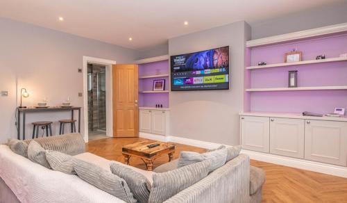 a living room with a couch and a tv at Central Skipton - Devonshire Court Apartments in Skipton