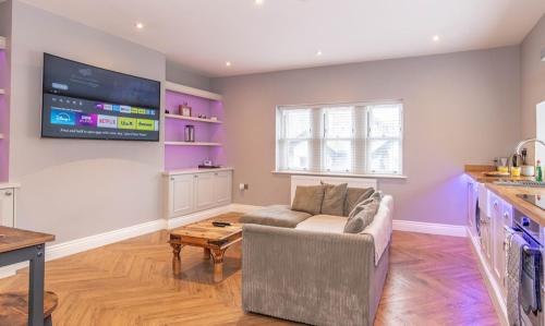 a living room with a couch and a flat screen tv at Central Skipton - Devonshire Court Apartments in Skipton