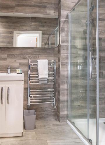a bathroom with a shower and a sink at Central Skipton - Devonshire Court Apartments in Skipton