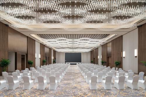 a conference room with white chairs and a large chandelier at Holiday Inn Hangzhou GCEC in Hangzhou