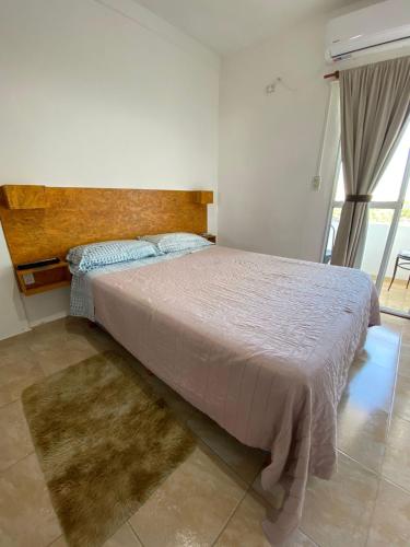 a bedroom with a large bed with a wooden headboard at Departamento Gallino in Corrientes