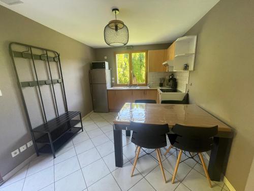 une cuisine avec une grande table et des chaises en bois dans l'établissement Appartement entre lac et montagnes, à Thônes