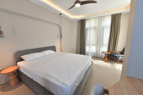 a bedroom with a white bed and a chair at Casalita Hotel in Kizkalesi