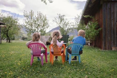 three children sitting in chairs in the grass at Payrgut in St. Wolfgang