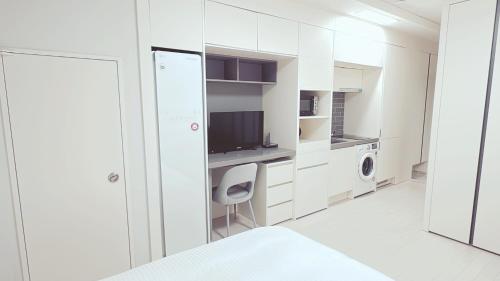a white room with a bed and a desk and a chair at The Time hotel Incheon Airport in Incheon