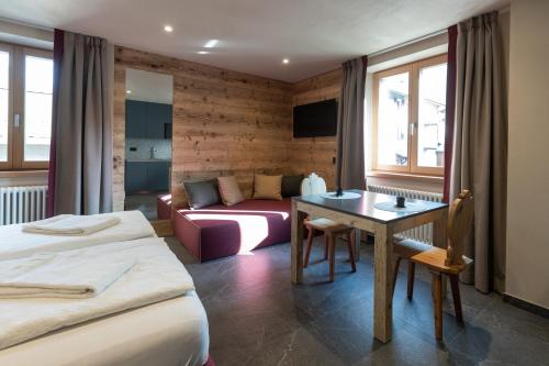 a hotel room with two beds and a couch at BAITA LARIX BORMIO in Bormio