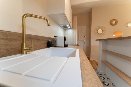 - une cuisine avec un évier blanc et un robinet dans l'établissement Beau 2P au centre ville de Nice, à Nice