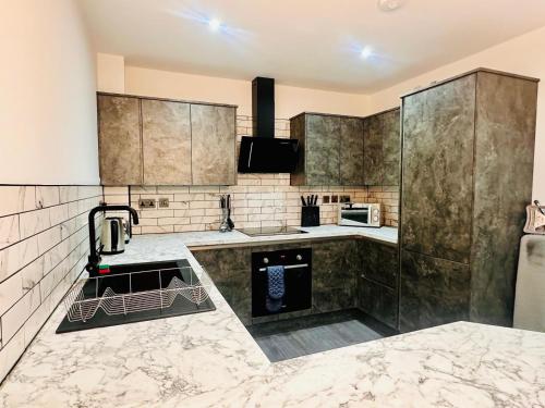 a kitchen with marble counter tops and stainless steel appliances at Under New Top Rated Management I Stylish 2BR Apartments I Central Hub I Free Parking I Work Ready Amenities in Peterborough