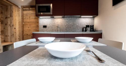 a kitchen with two white bowls on a table at BAITA LARIX BORMIO in Bormio