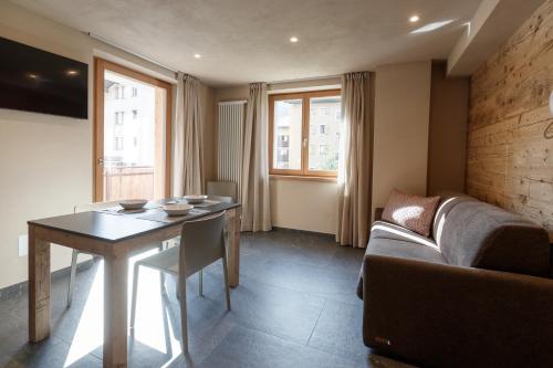 a living room with a table and a couch at BAITA LARIX BORMIO in Bormio