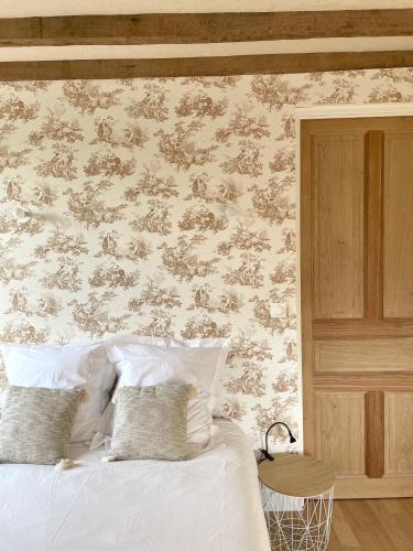 a bedroom with a bed with a floral wall at Entre les branches in Saint-Règle