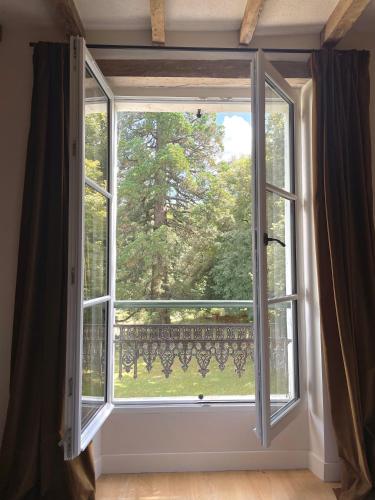 an open window with a view of a garden at Entre les branches in Saint-Règle