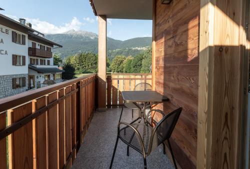 a patio with a table and chairs on a balcony at BAITA LARIX BORMIO in Bormio